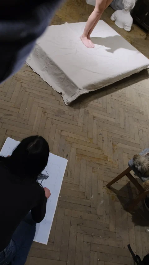 Lady learns to paint picture on large sheet of paper in studio Stock Footage 306458294