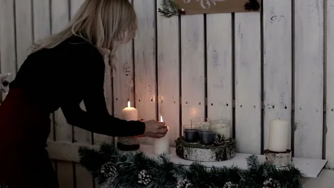 A lady lights candles. The warmth and atmosphere of the Christmas holiday Stock Footage 99201558