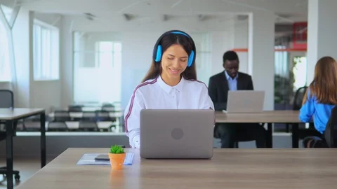 Lady listening to music while working in office Stock Footage 111753424