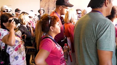 A lady is looking into camera while a group of tourists is waiting in front. Stock Footage 152686531
