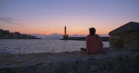Lady Looking At Lighthouse In A Harbour At Sunset Stock Footage 119699312