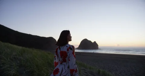 Lady looking out to sunset beach Stock Footage 125413875