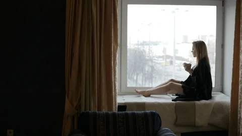 Lady is looking out the window Video stock 85860755