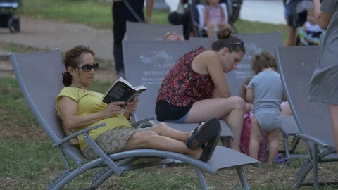 A Lady Lying On A Sunbed Reads A Book At Tel Aviv Park Stock Footage 90388995