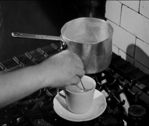 Lady making a cup of tea for a young adolescent boy, United Kingdom, UK, 1946 Stock Footage 133383490