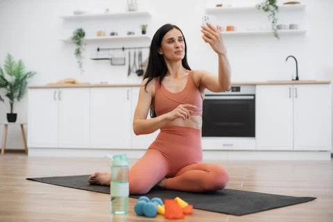 Lady making selfie on smartphone while training on yoga mat Foto stock