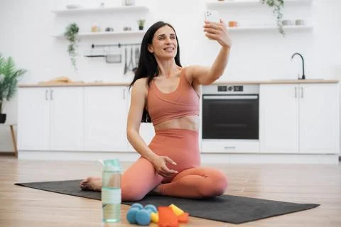 Lady making selfie on smartphone while training on yoga mat Fotos Stock