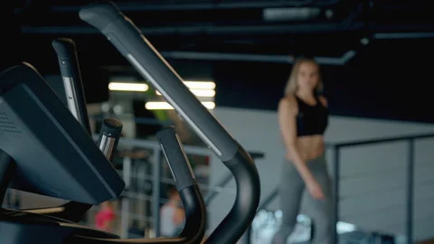 Lady making workout on orbitrek in gym Stock Footage 109407162