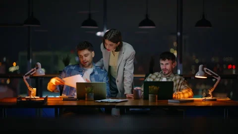 Lady mentor consulting managers dark windows office. Late team working laptops Stock Footage 339299749
