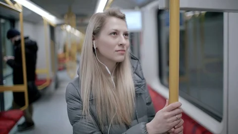 Lady in metro listening to the music in headphones	 Stock Footage