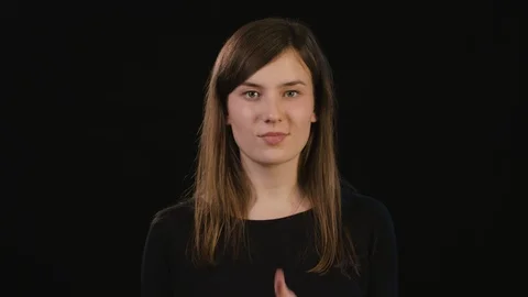 A Lady Mimicing Against a Black Background Stock Footage 87184344