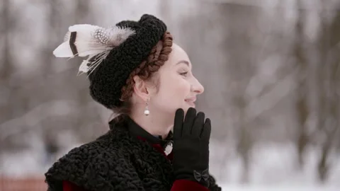 A lady in an old-fashioned suit, shining against a background of white snow  库存影片 301295484
