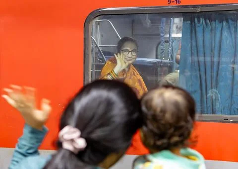 Lady passenger Sitting Inside Train saying bye bye to loved one at railway .. Stock Photos