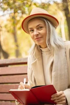 Lady with a pen sitting on the bench Stock Photos