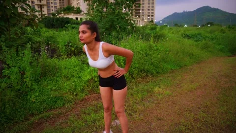 Lady performs bend exercise in quiet farmland area Stock Footage 308616675