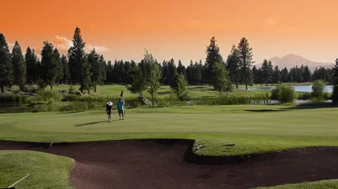 Lady playing golf with man at golf course Sisters Oregon Видео 37208399
