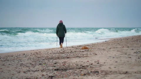 Lady practicing Nordic walking on sandy beach Video stock 201895608