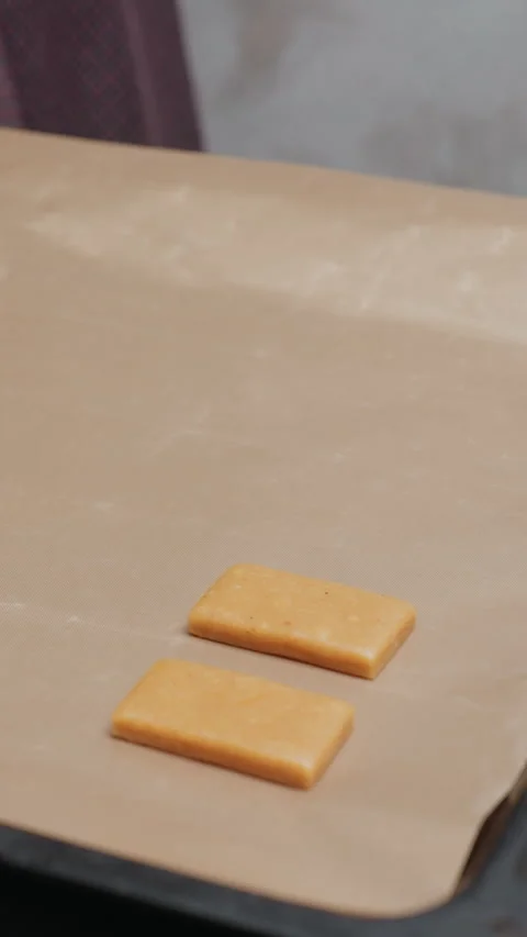 Lady preparing to place freshly cut dough on baking tray for oven Stock Footage 320340210