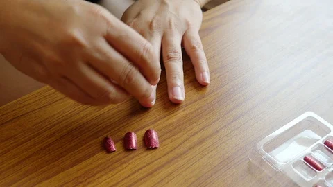 Lady putting artificial red color nail Stock Footage 101005818