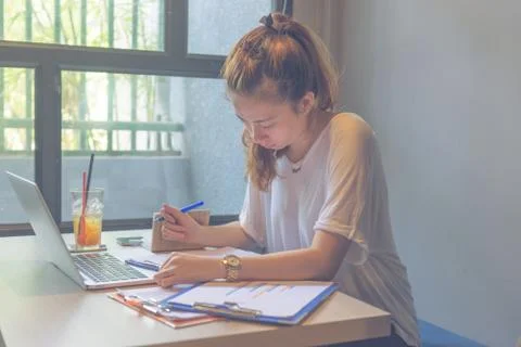 Lady reading chart reports in front of laptop Stock Photos