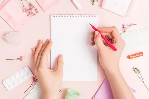 Lady with red felt-tip pen over notepad on pink background with pills and s.. Stock Photos