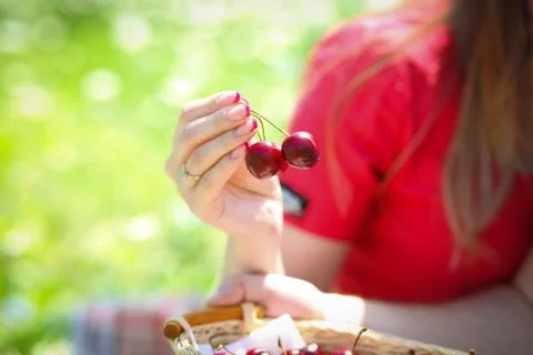 Lady in red holds two cherry berries Stock Photos