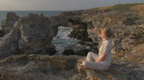 Lady relaxing on the beach, coastline sunrise fresh relax female blonde hair Stock Footage