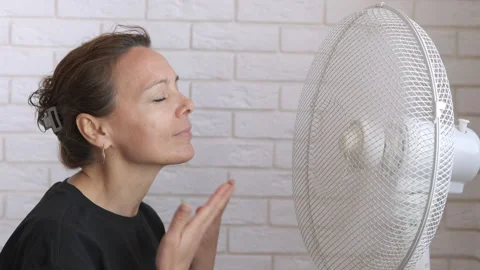 Lady resting by electric fan in flat. Stock Footage 309002103