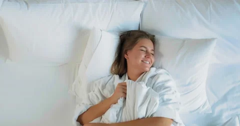 Lady rests lying on comfortable bed with pillows and blanket Stock Footage 140984463