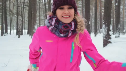 Lady runs along forest path pulling sled with daughters Stockbeeldmateriaal 134236717
