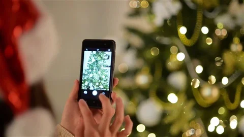 Lady in Santa Hat Doing Snapshot of Christmas Tree by Smartphone. Beautiful Stock Footage 70682519