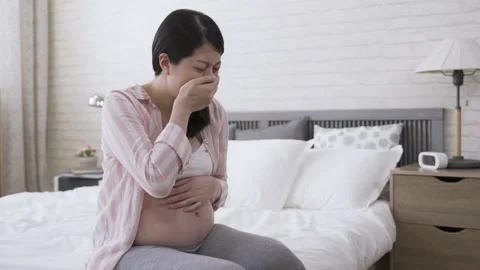 Lady seated on bedside covering her mouth Stock Footage 149593537