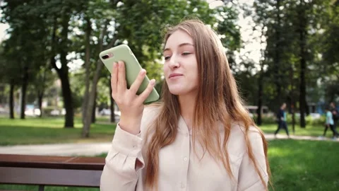 Lady sending audio voice message on smart phone at outdoor talking to mobile Video stock 141611328