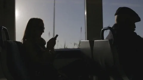 Lady sends message from phone, in train, silhouette, wide shot. Stock Footage 82328612