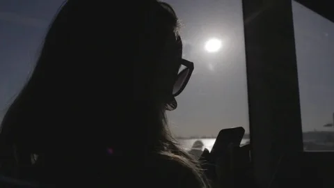 Lady sends message from phone on train, silhouette, close up. Stock Footage 82328633