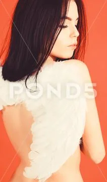 Lady sexi dressed as angel, red background, rear view. Woman on calm face play Stock Photos