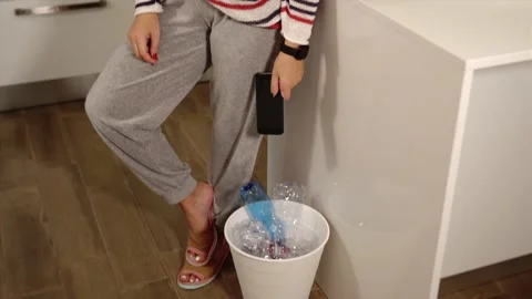 Lady shakes broken smartphone throws into white rubbish bin Video stock 141364322