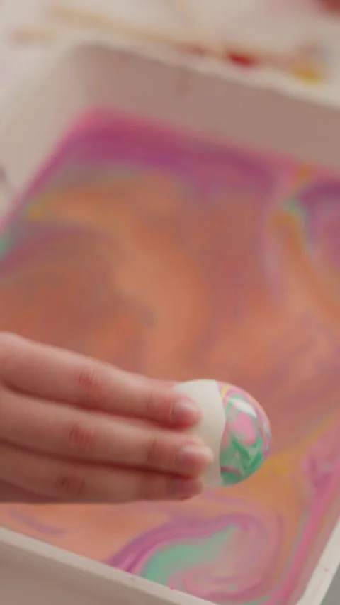 Lady shows Easter egg with abstract pattern of Ebru art Stock Footage 273897811
