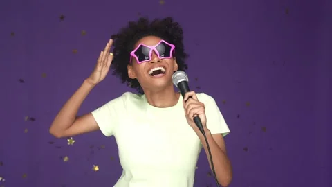 Lady sing mic star shape glasses fall confetti isolated violet color background Stock Footage 165878989