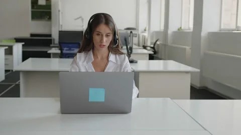 Lady sits in office and does her online work Video stock 157969128