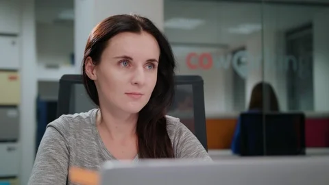 A Lady Sitting in the Office in Front of a Laptop Stock Footage 86405589