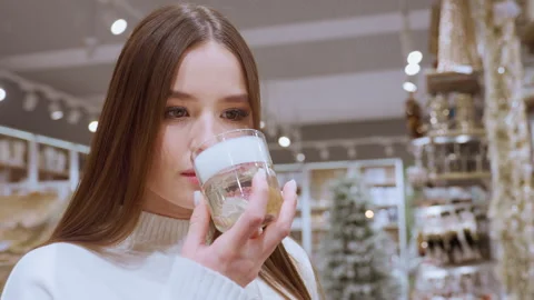 Lady smelling perfume in mall store with other shoppers in background Stock-Footage 319678243