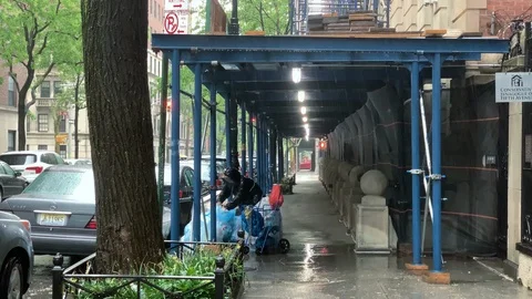 Lady sorting bottles recycling in the rain under scaffolding - raining NYC 스톡 동영상 108198304