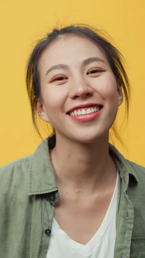 Lady stand on isolate yellow empty space background looking at camera. 動画素材 347193888