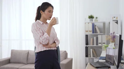 Lady standing drinking tea is looking at screen Video stock 133697947