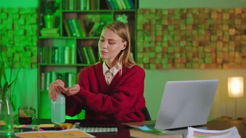 Lady before start to work in front of the laptop take some antiseptic gel and Stock Footage 135598360