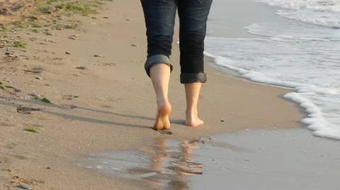 Lady stepping on the beach and waves touching her feet Stock Footage 12274429