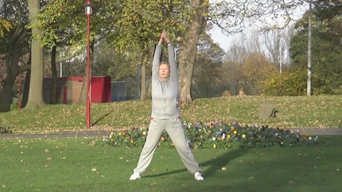 Lady stretches in a park Stock Footage 87741713