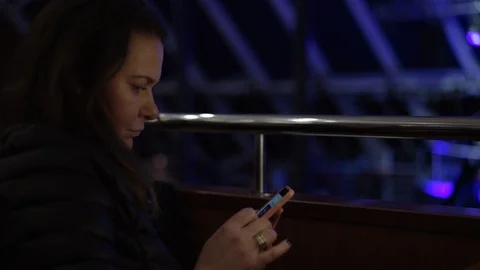 Lady surfs social network using phone against dancing people Video stock 122245697