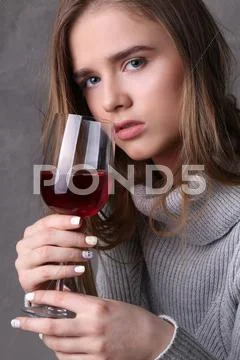 Lady In Sweater Holding Wineglass. Close Up. Gray Background